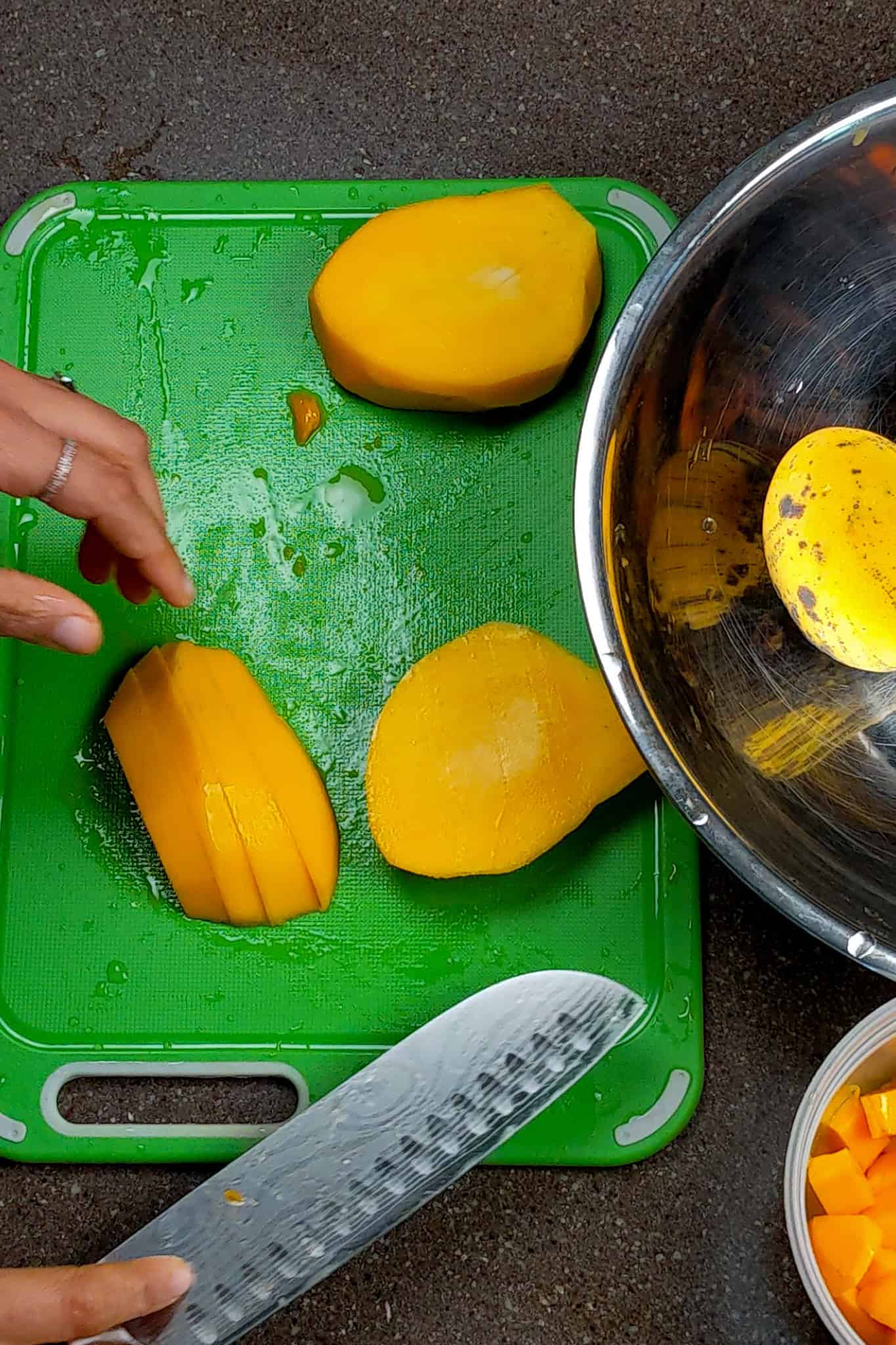 slicing the mango into even thick strips.