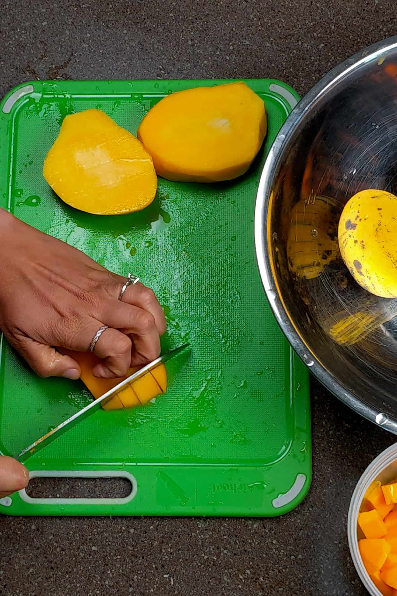 dicing the mango into even pieces with fingers tucked in.