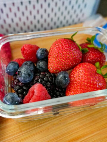 up-close view of mixed berries in an air tight glass container.