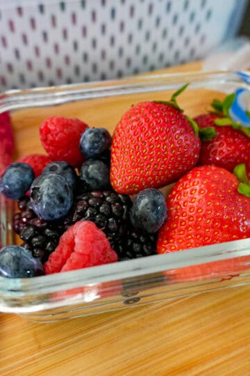 up-close view of mixed berries in an air tight glass container.