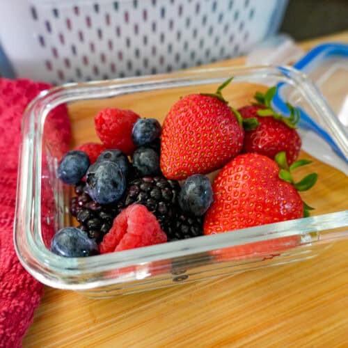 up-close view of mixed berries in an air tight glass container.