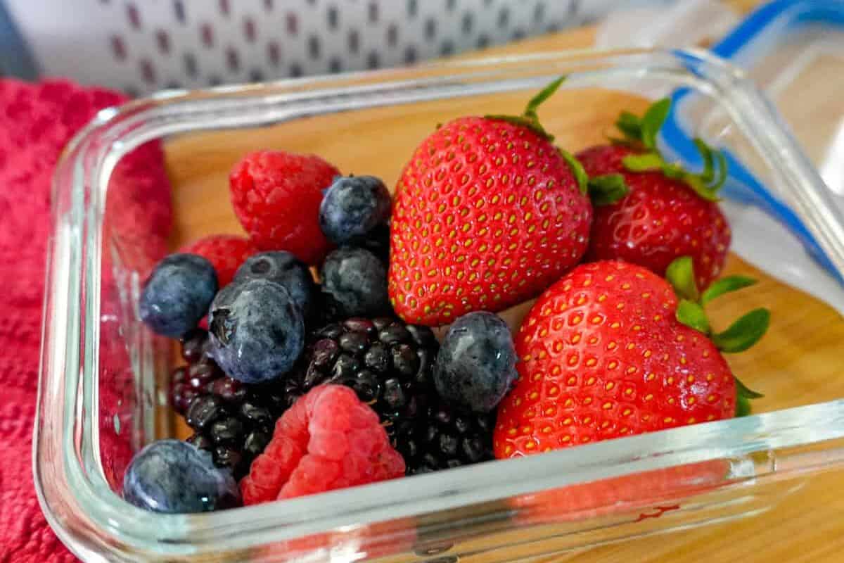 up-close view of mixed berries in an air tight glass container.