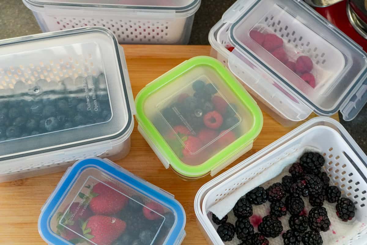 2 sets of mixed berries in air tight glass containers with snap on plastic lids and fruit storage containers.
