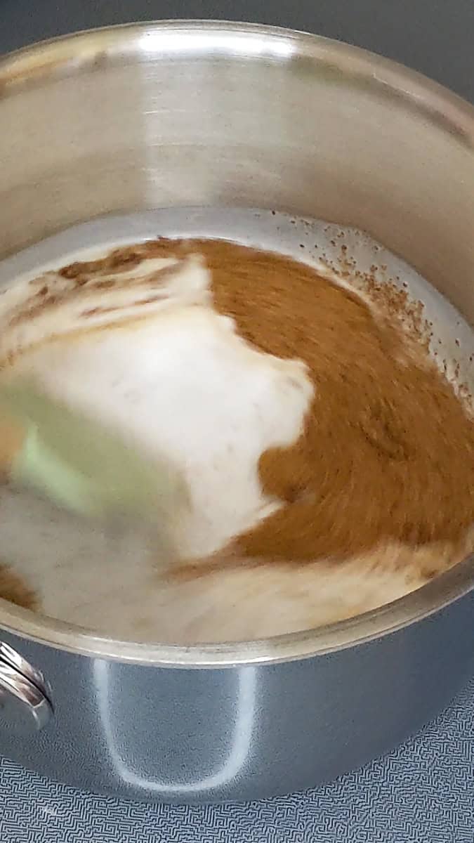 mixing coconut milk and coconut sugar in saucepan.