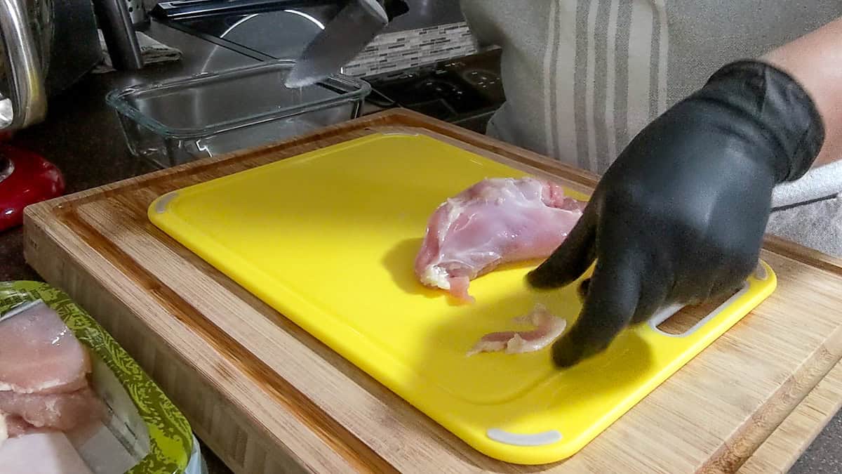 piece of trimmed fat from chicken thigh placed to the side on cutting board.