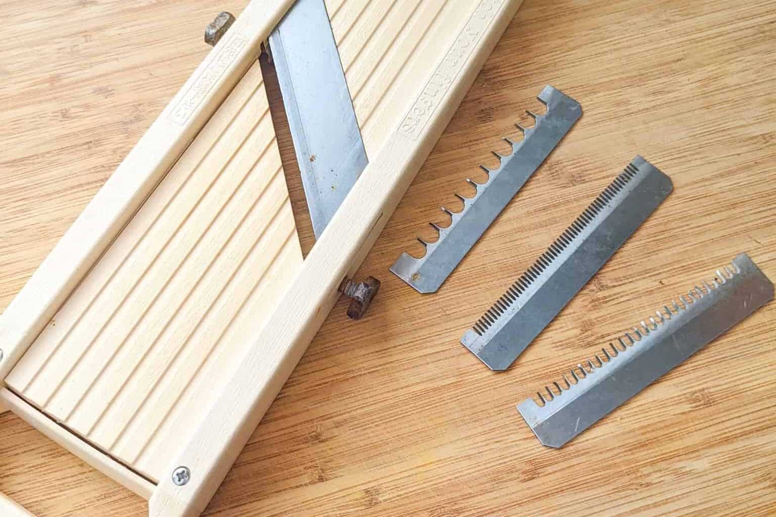 the Benriner Vegetable Slicer with three different blades next to it.