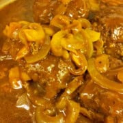 Close-up of Salisbury steak with mushroom gravy and sliced mushrooms.
