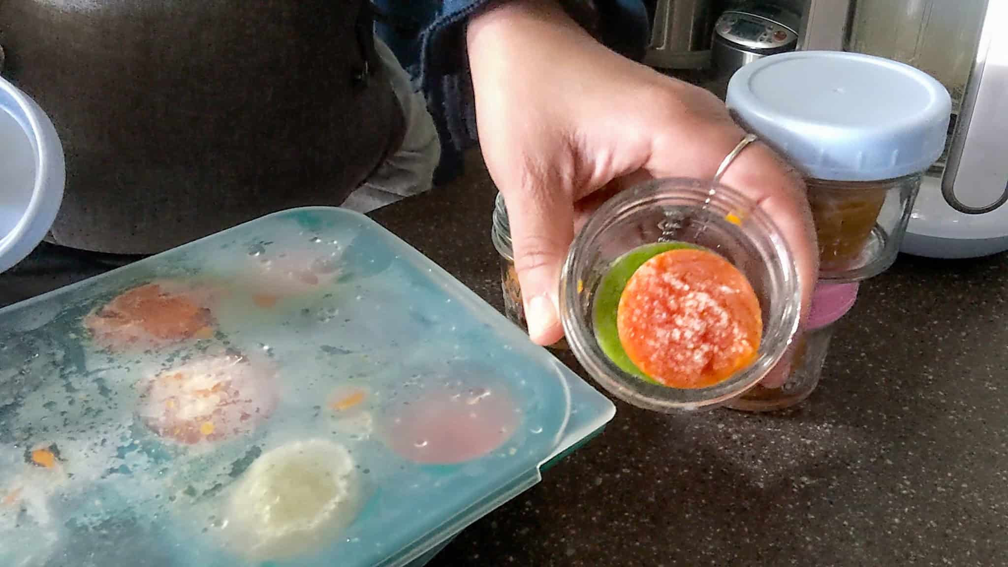 portioned frozen carrot and broccoli puree in glass baby food jars.