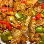 Chinese pepper steak recipe with red wine, hoisin sauce, bell peppers, and mushrooms.