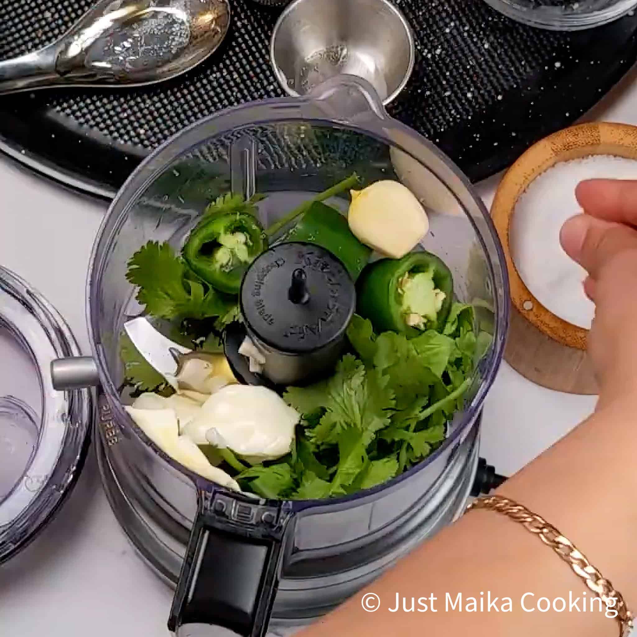 Chopped cilantro, jalapeños, and garlic in a food processor for sauce.