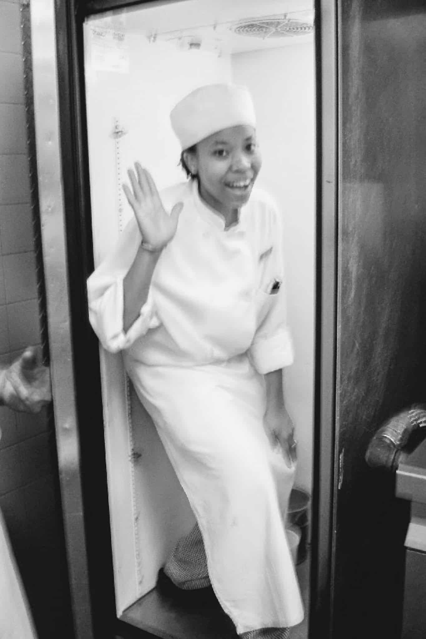Young chef maika as a cook at the Ritz Carlton. In a funny pick wavy to the camera while halfway inside a tall fridge.