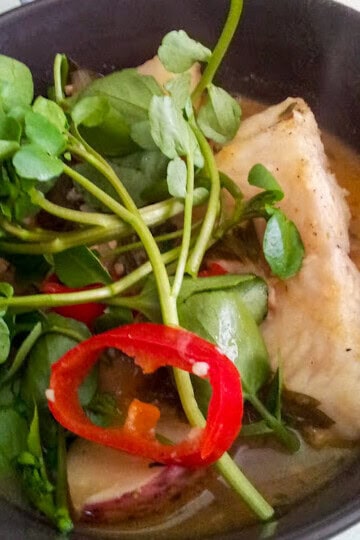 Spicy basa fish stew with potatoes, red peppers, and fresh watercress.