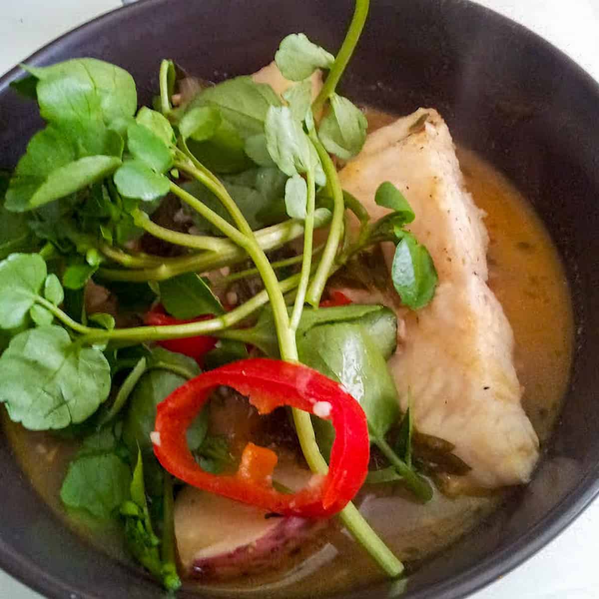 Spicy basa fish stew with potatoes, red peppers, and fresh watercress.