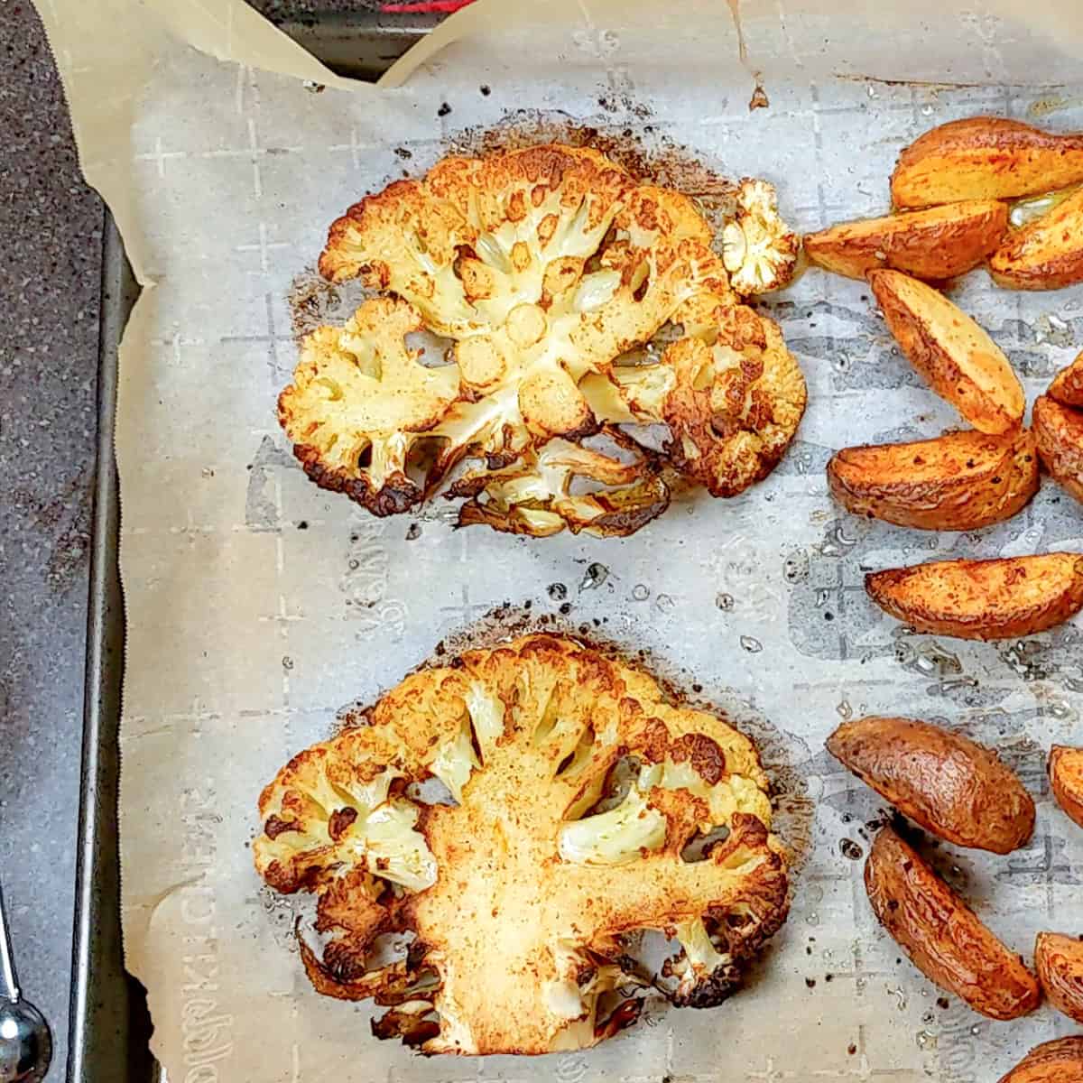 Golden Brown cauliflower steaks on a sheet pan.
