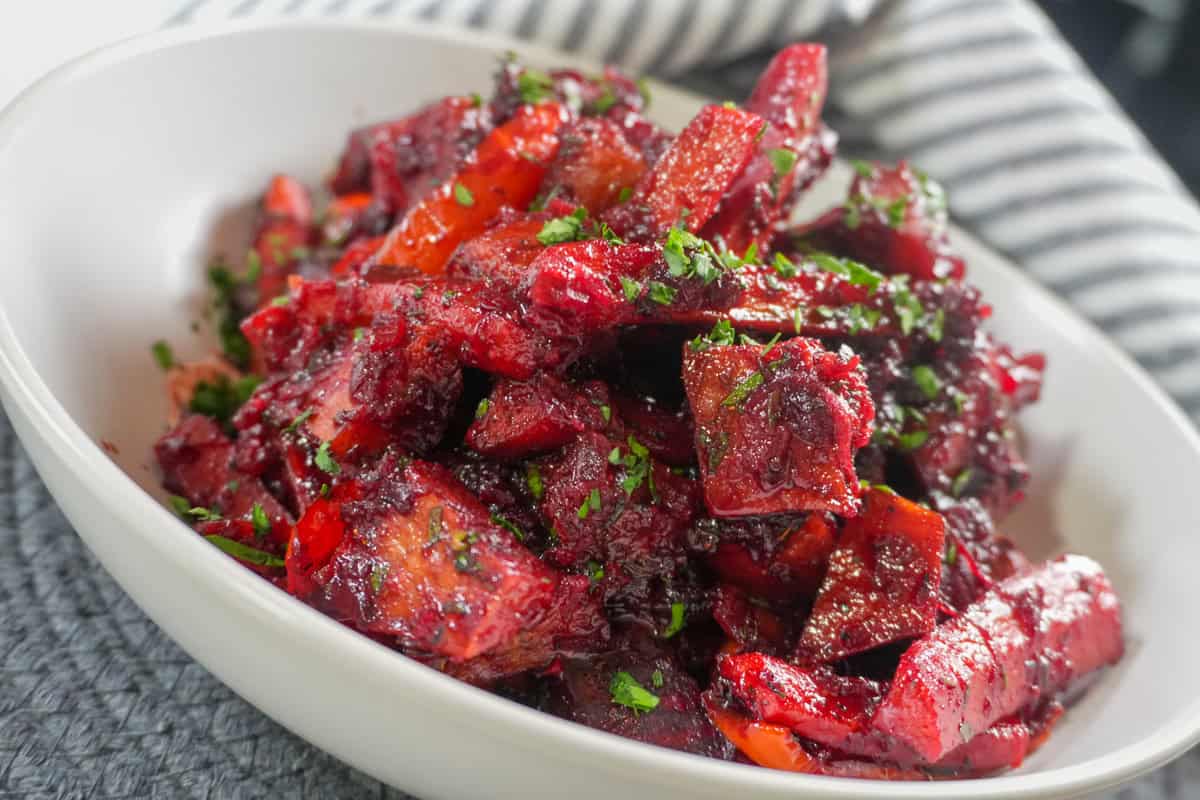 Roasted sweet potatoes, carrots, red peppers, and beets coated in a glossy red beet glaze.