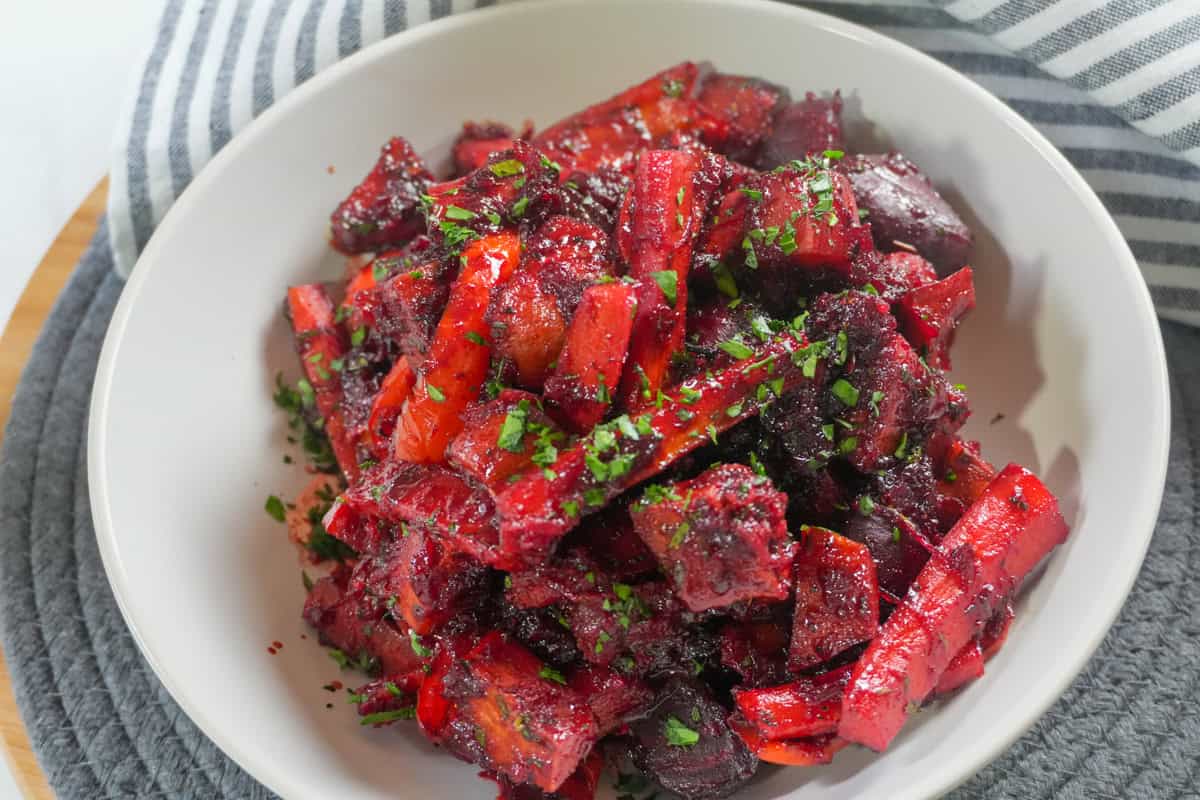 Roasted sweet potatoes, carrots, red peppers, and beets coated in a glossy red beet glaze.