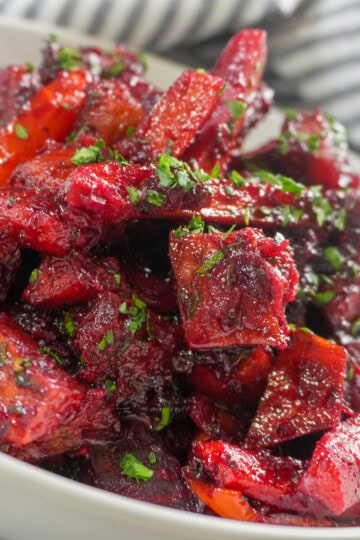 Roasted sweet potatoes, carrots, red peppers, and beets coated in a glossy red beet glaze.