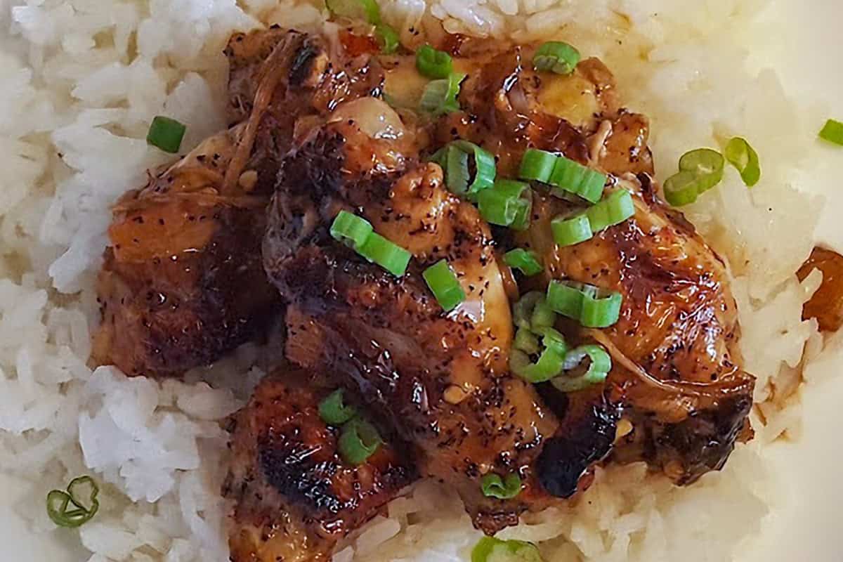 Soy ginger chicken drumettes over jasmine rice with sliced scallions.